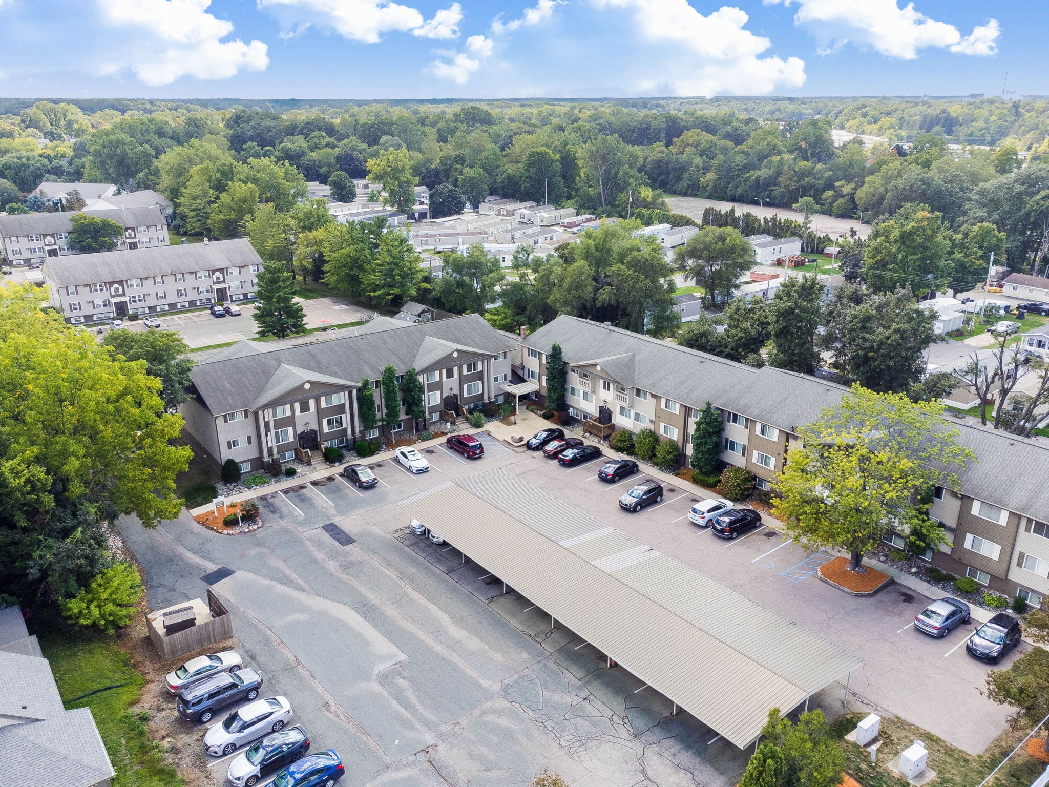 A parking lot is surrounded by apartment buildings.